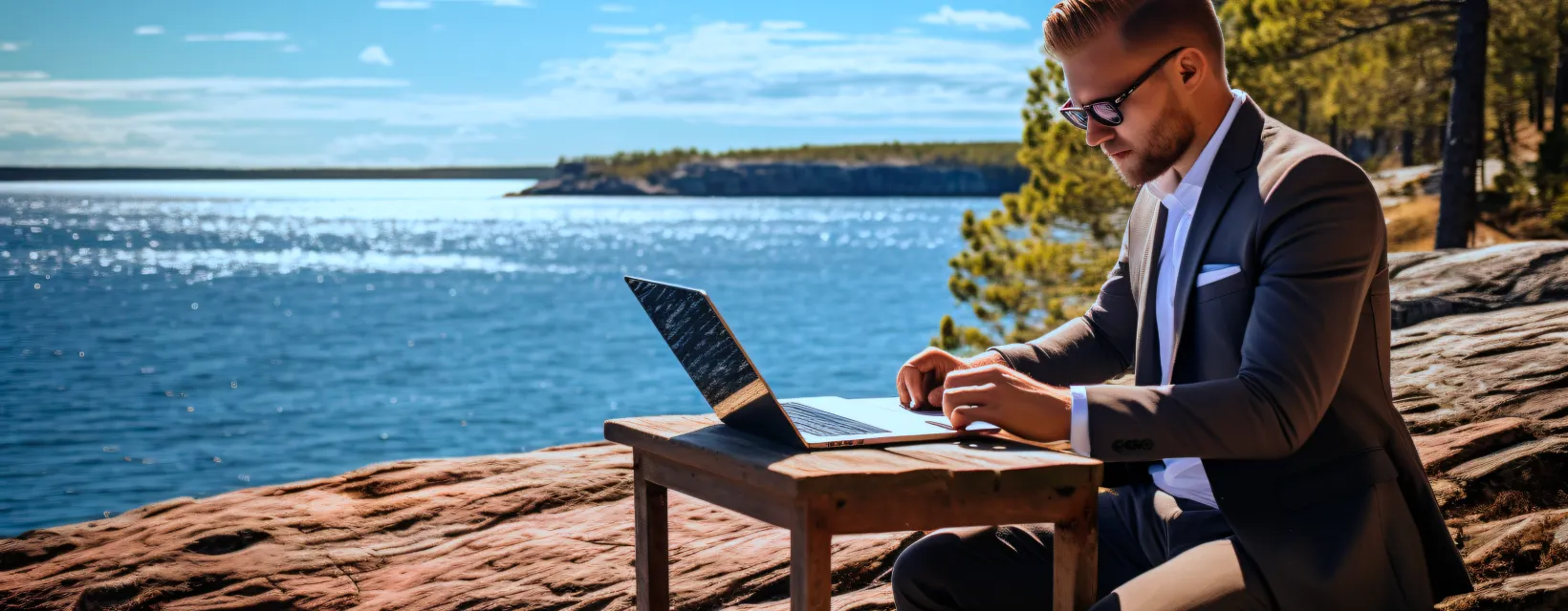 Man jobbar på distans från Åland, utomhus på granitröda klippor.