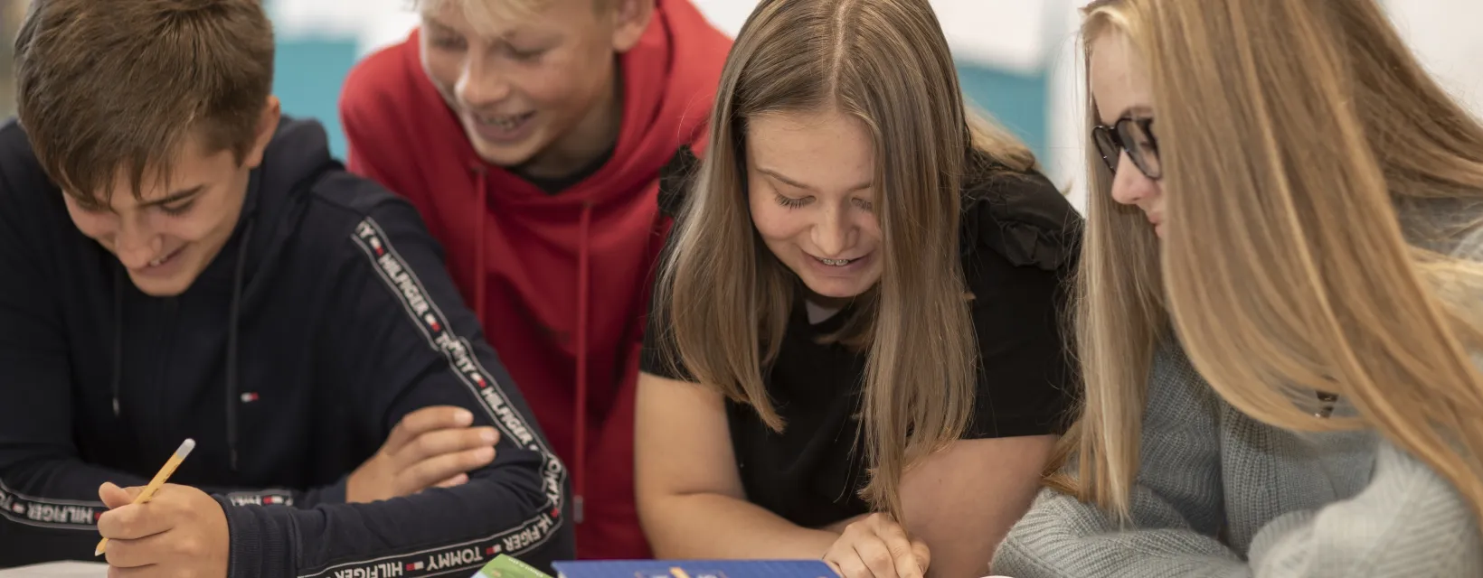 Skolbarn som lutar sig in över skolböckerna vid Övernäs högstadieskola i Mariehamn.