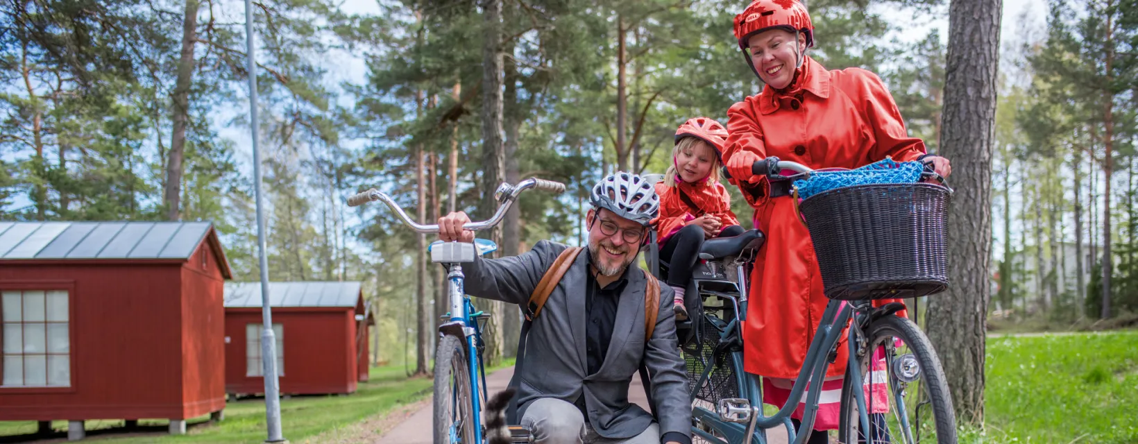 Familj med cykel stannar och hälsar på katt vid Gröna Udden på Åland.