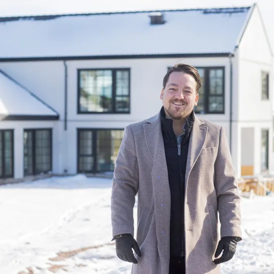 André Schill framför sitt nya hus på Möckelö Strand, Åland.