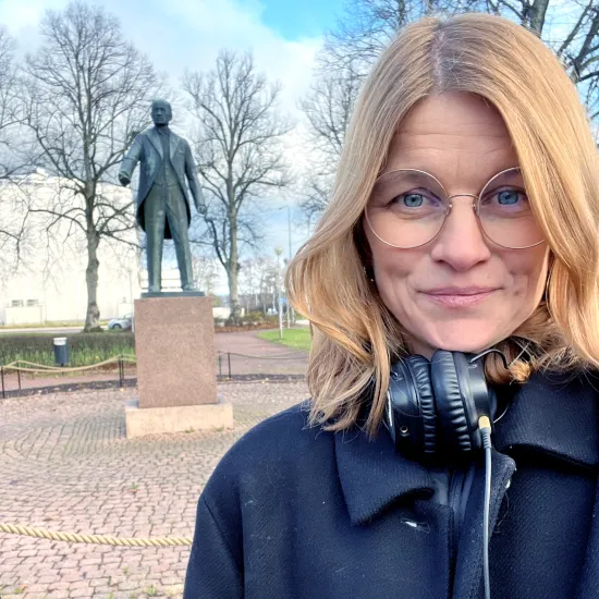 Hanna Saurén framför Julius Sundbloms staty vid torget i Mariehamn.