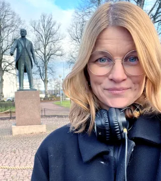 Hanna Saurén framför Julius Sundbloms staty vid torget i Mariehamn.