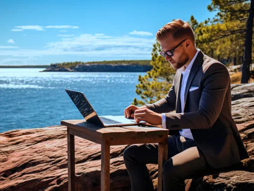 Man jobbar på distans från Åland, utomhus på granitröda klippor.
